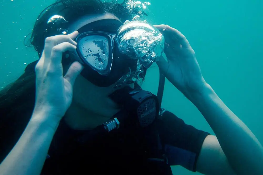 why do divers spit in their masks